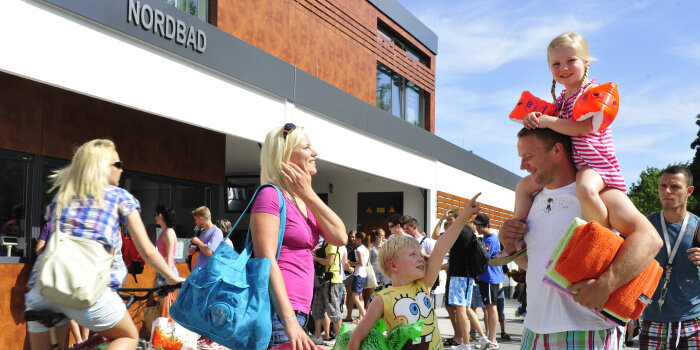 Eine Familie und weitere Menschen stehen vor dem Eingang des Erfurter Nordbad.