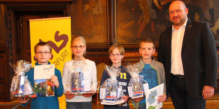 Foto: Siegerehrung Heynrich-Schreyber-Wettbewerb 2015 © Stadtverwaltung Erfurt 4 Kinder mit Urkunden und Präsenten mit dem Leiter der Erfurter Volkshochschule im Rathausfestsaal.
