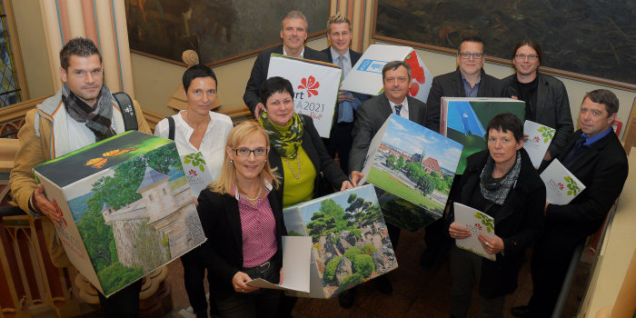 Gruppe von Menschen hält Würfel mit Motiven zur Bundesgartenschau 2021 in Erfurt in den Händen.