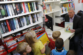 Der Oberbürgermeister sitzt an der Theke der Fahrbibliothek.