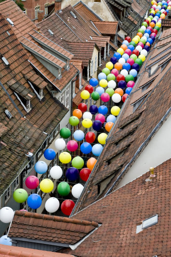 Blick von oben auf die Krämerbrücke, zwischen den Häusern hängen bunte Luftballons. 
