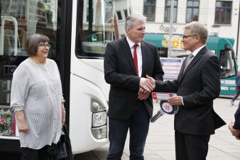 Foto: Übergabe Fahrbibliothek © Stadtverwaltung Erfurt Zwei männliche Personen schütteln sich die Hände, rechts daneben steht eine Frau.
