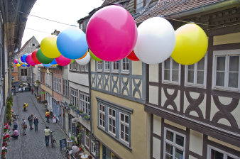 Blick aus einem Fenster; man sieht die Krämerbrücke und viele bunte Luftballons, die zwischen den Häusern aufgehangen wurden. 