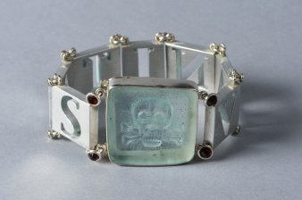 Foto: Armband Vanitas, 2006, Silber, Aluminium, Glas, Markasit, Granat, 23,5 x 3,6 x 1 cm © Rolf Lindner, Foto: Thomas Wolf Silbernes Armband mit integriertem Totenkopf.