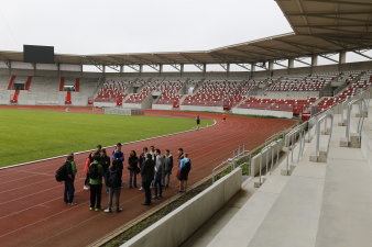 Eine Schülergruppe steht auf der Tartanbahn im Innenraum der Multikunktionsarena.