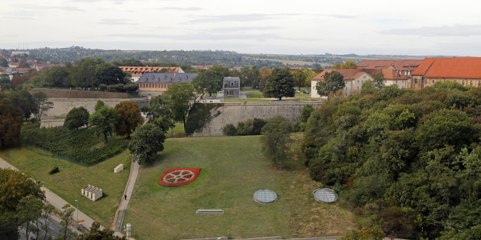 Foto: Südöstlicher Petersberghang mit Wappenbepflanzung © Stadtverwaltung Erfurt grüner Hang mit Bebauung im Hintergrund