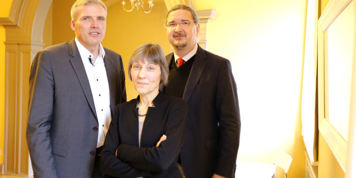Oberbürgermeister Andreeas Bausewein und zwei Vertreter des Vereins Erfurter Herbstlese, eine Frau und ein Mann, stehen in einem gelben Salon im Haus Dacheröden. 