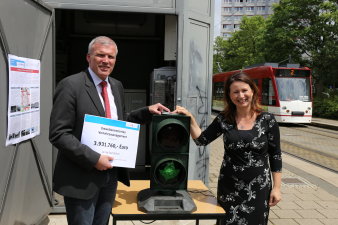 Foto: Übergabe des Fördermittelbescheides für das umweltorientierte Verkehrsmanagement © Stadtverwaltung Erfurt Eine Frau übergibt an einem Mann einen symbolischen Scheck