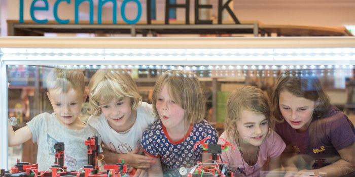 Foto: Kinder in der Technothek der Kinder- und Jugendbibliothek © Melanie Kahl Fünf Kinder bestaunen die Modelle in der Technothek.