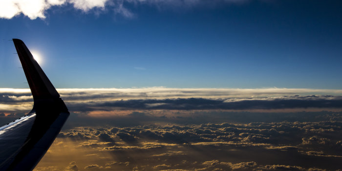 Ein Teil eines Flugzeuges, dass gerade über den Wolken fliegt