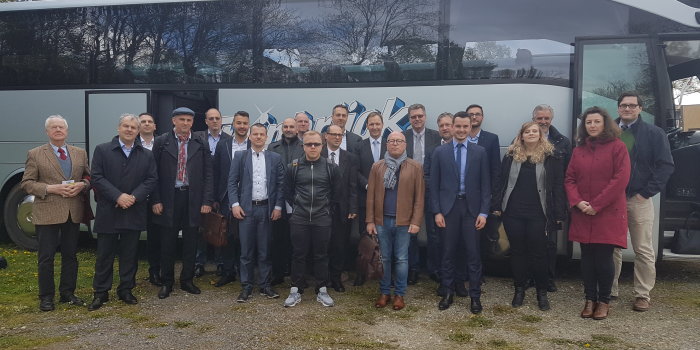 Frauen und Männer stehen vor einem Reisebus.