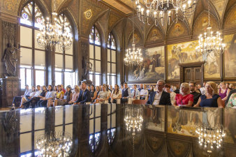 Blick in den Festsaal, in dem die neuen Mitarbeiter sitzen und den Reden zuhören