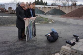 Foto: Teile des Renau-Wandbildes © Stadtverwaltung Erfurt Drei Männer halten ein Bild, davor liegt ein Fotograf