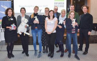 Sieben Frauen und drei Männer, davon einige mit einem weißen Stoff-Känguru in der Hand, bei einer Preisverleihung.