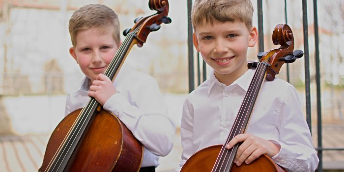 zwei Kinder mit ihren Cellos