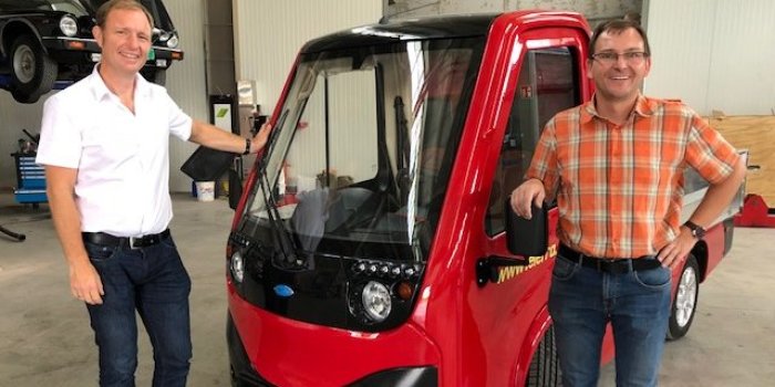 Foto: Besuch bei Elerra © Stadtverwaltung Erfurt Zwei Männer stehen neben einem kleinen Elektroauto