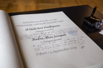 aufgeschlagenes Buch mit kalligrafischen Text und Unterschrift