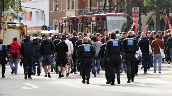 viele Menschen begleitet von Polizisten