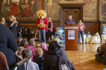 Kinder und Erwachsene hören der Rednerin zu