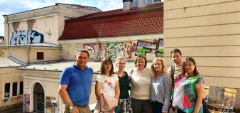 Gruppenfoto, im Hintergrund mit Graffiti bemaltes Gebäude