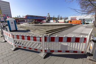 Baustellengitter grenzen die Baustelle an einer alten Betonumfassung - Brunnen ab