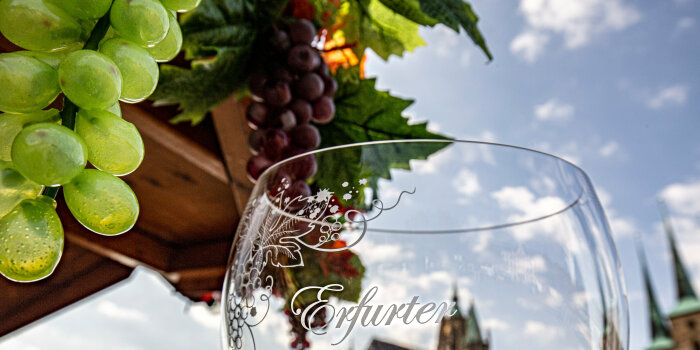 Foto: Weinfest auf dem Domplatz © Stadtverwaltung Erfurt Ein Weinglas vor Weinranken mit dem Dom als Hintergrund