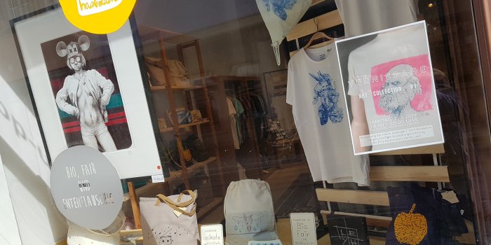 Ein Schaufenster aus Bildern, Taschen und T-Shirts. 
