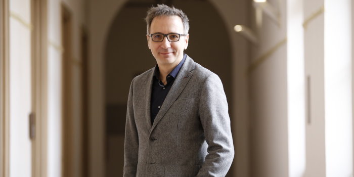 Foto: Daniel Baumbach © Stadtverwaltung Erfurt Ein Mann mit grauen Haaren, Brille und grauer Jacke steht in einem Gang.