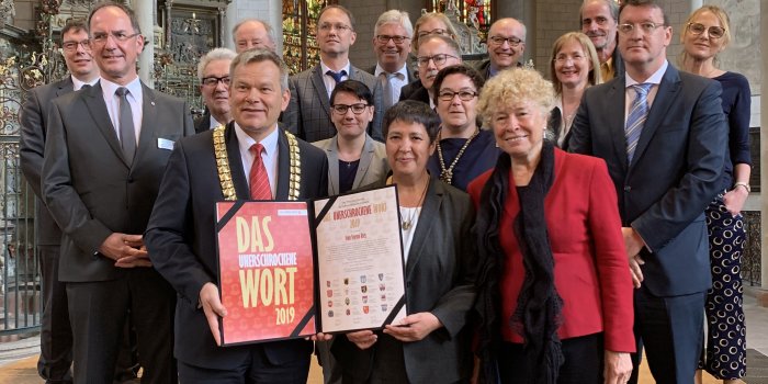 Foto: Preisverleihung „Das unerschrockene Wort“ 2019 an Seyran Ateş © Stadtverwaltung Erfurt Ein Mann überreicht einer Frau eine Urkunde, weitere Menschen stehen dabei
