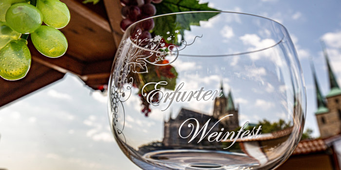 Foto: Weinfest auf dem Domplatz © Stadtverwaltung Erfurt Ein Weinglas vor Weinranken mit dem Dom als Hintergrund