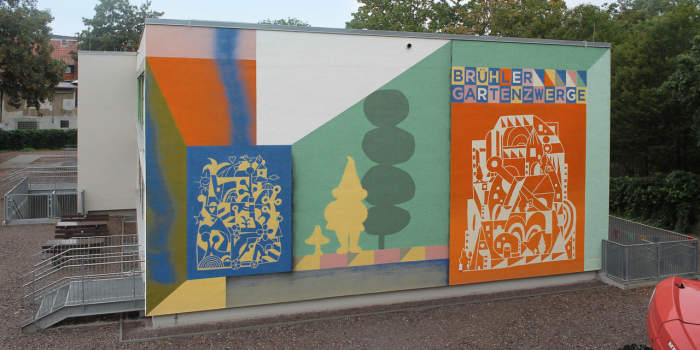 bemalte Wand mit abstrakten Formen und Name Brühler Gartenzwerge