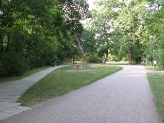 einige Spielgeräte für Kleinkinder in einer Parklandschaft