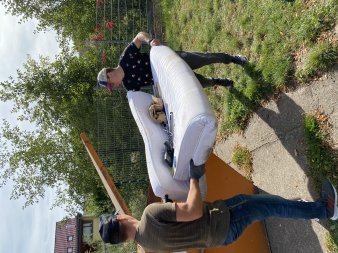 Foto: Große Begeisterung für Umweltschutz in Vieselbach © CPB Zwei Helfer tragen eine alte Couch in den Container