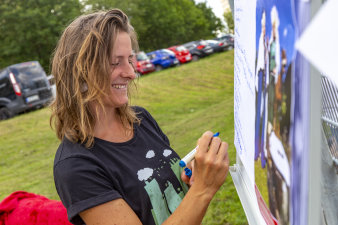 eine Frau steht auf einer Grünfläche und notiert Stichpunkte auf einem Flipchart