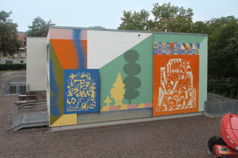 bemalte Wand mit abstrakten Formen und Name Brühler Gartenzwerge