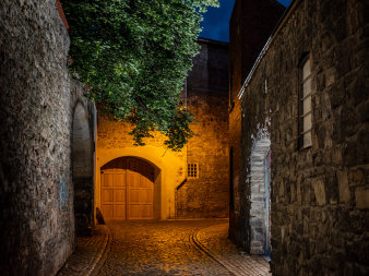 Eine mittelalterliche Gasse bei Nacht aufgenommen.