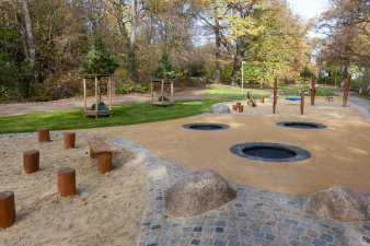 ein Spielplatz inmitten einer Parklandschaft