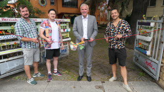 Mehrere Personen schneiden mit Scheeren ein Band durch