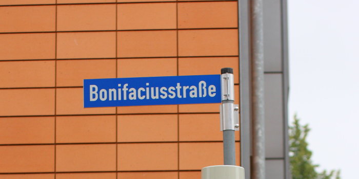 ein Straßenschild mit dem Schriftzug Bonifaciusstraße über einer grünen Fußgängerampel