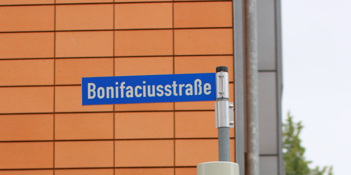 Foto: Verkehrsfreigabe Bonifaciusstraße © Stadtverwaltung Erfurt ein Straßenschild mit dem Schriftzug Bonifaciusstraße über einer grünen Fußgängerampel