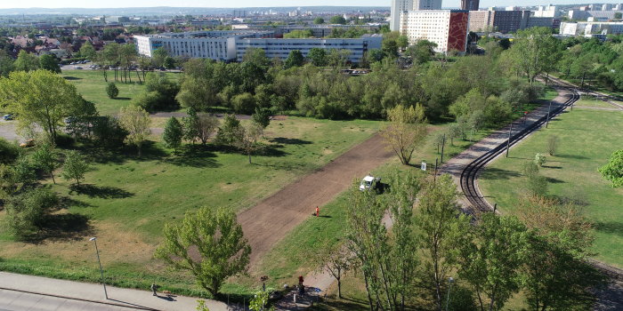 Foto: Ansaat Blumenwiese Zoopark Roter Berg © Stadtverwaltung Erfurt Luftaufnahme einer Grünfläche, auf der eine rechteckige Fläche bearbeitet wird