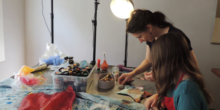 Foto: Im Kunst-Labor 2020 mit Britta Schatton © Stadtverwaltung Erfurt eine Frau und ein Mädchen arbeiten an einem Tisch künsterlisch mit Stoff