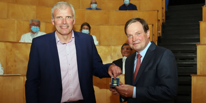 Foto: Ehrenmedaille für Prof. Dr. Stier © Helios Klinikum Erfurt Zwei Männer im Anzug, der Größere übergibt dem Kleineren eine Medaille.