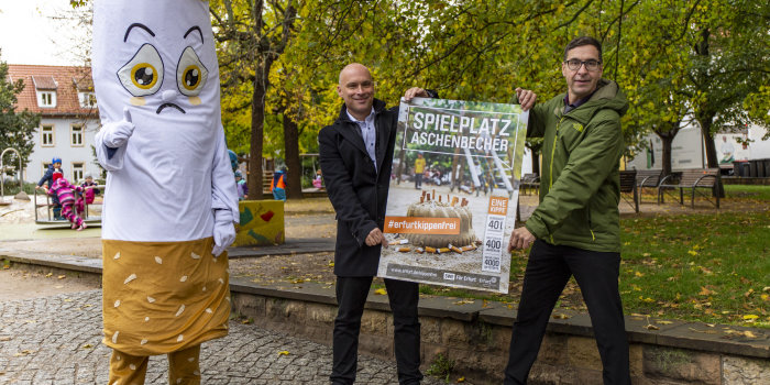 Foto: Teil 2 der Sauberkeitskampagne #ErfurtKippenfrei © Stadtverwaltung Erfurt Zwei Männer halten ein Plakat. Neben ihnen steht eine übergroße Figur in Form einer Zigarette.
