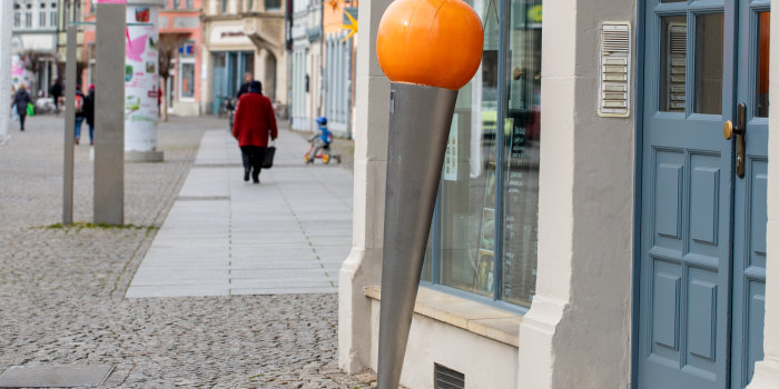Foto: Jüdische Denknadel am Domplatz © Stadtverwaltung Erfurt / G. Kästner ein umgekehrt zylinderförmiger Metallsockel mit einer farbigen runden Kugel als Abschluss