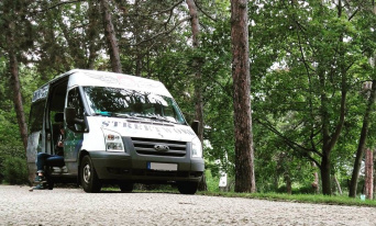 Streetworkbus der Erfurter Streetworker ein Transporter mit offener Schiebetür, in der ein Mensche mit dem Handy in der Hand sitzt