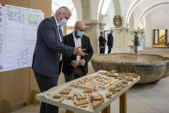 zwei Männer stehen vor einem architektonischen Holzmodell