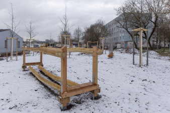 ein großes Spiel- und Sportgerät aus Holz in einer verschneiten Park-Baustelle