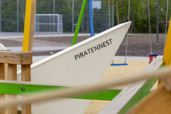 ein Spielplatz, darauf ein Boot aus Holz mit der Aufschrift "Piratennest"