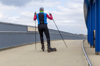 ein Ski-Skater fährt über eine Brücke